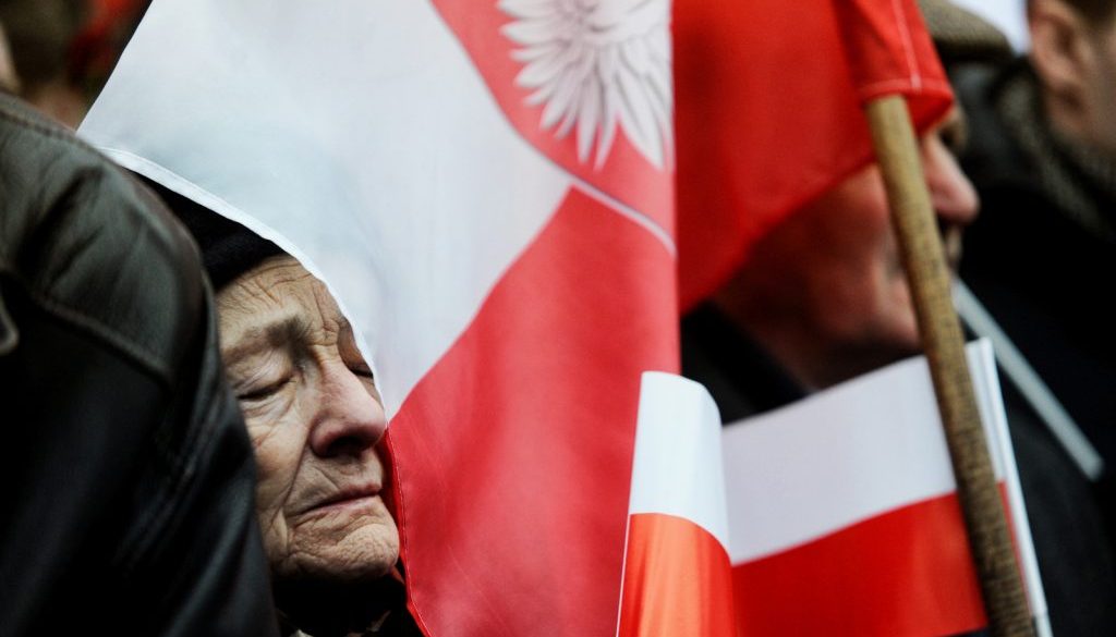 gillert maciej interfoto polka w podeszłym wieku z zamknietymi oczami oparta o flage polski